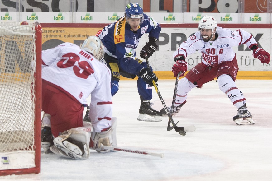 Biels Gaetan Haas, Mitte, kaempft um den Puck gegen Lausannes Goalie Cristobal Huet, links, und Etienne Froidevaux, rechts, waehrend dem Eishockey National League A Spiel zwischen dem EHC Biel und Lau ...