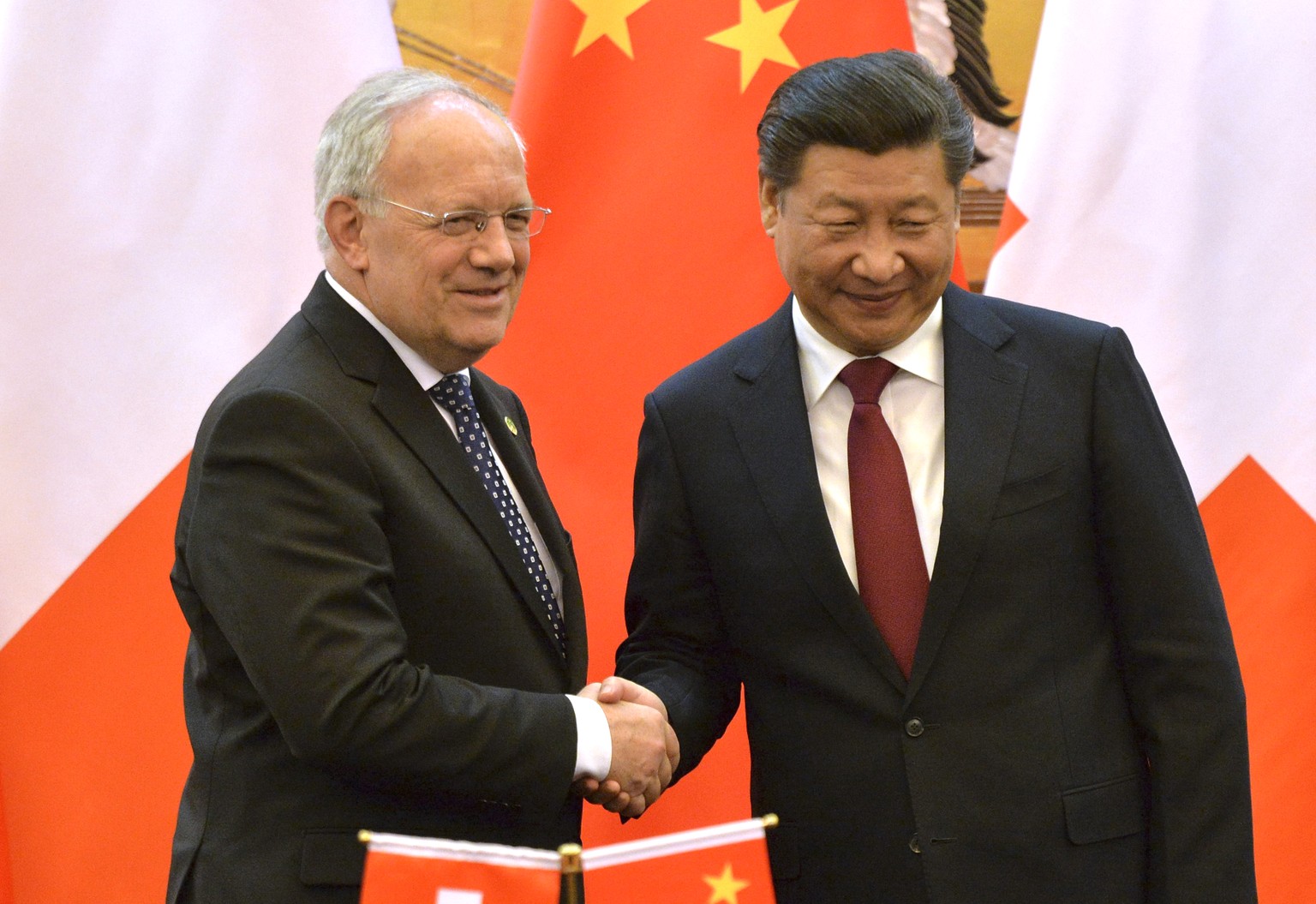 Switzerland&#039;s Federal President Johann Schneider-Ammann, left, and Chinese President Xi Jinping poses for photographers at the end of the signing ceremony at the Great Hall of the People in Beiji ...