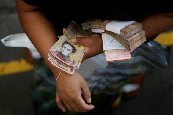 A customer counts Venezuelan bolivar notes at a market in downtown Caracas, Venezuela, December 7, 2016. REUTERS/Ueslei Marcelino