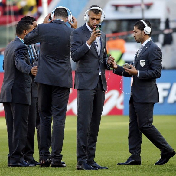 epa04273008 Islam Slimani of Algeria (2nd R) looks at his mobile phone as the team inspects the pitch before the FIFA World Cup 2014 group H preliminary round match between South Korea and Algeria at  ...