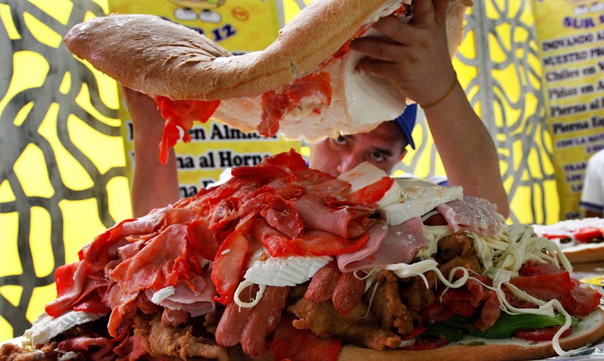 A cook prepares a giant torta, or sandwich, during a press conference to promote the 13th annual Torta Festival, in Mexico City, Wednesday, July 20, 2016. The five day festival presents a variety of t ...