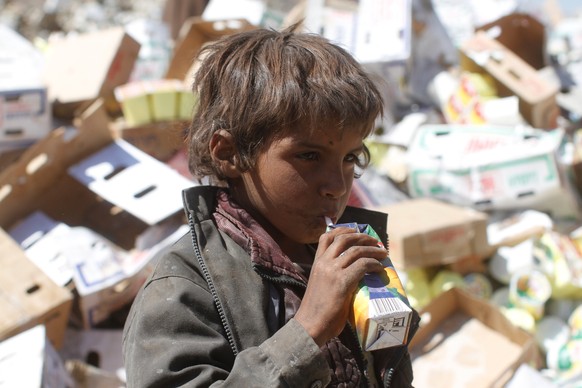 A boy drinks expired juice on a pile of rubbish at landfill site on the outskirts of Sanaa, Yemen November 16, 2016. REUTERS/Mohamed al-Sayaghi