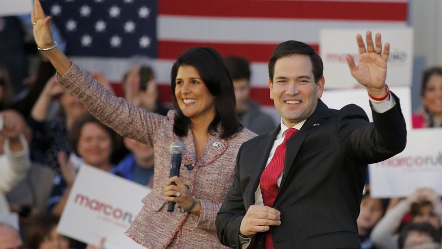 South Carolina Governor Nikki Haley (L) and U.S. Republican presidential candidate Marco Rubio (R) wave as they are announced on stage during a campaign event in Chapin, South Carolina February 17, 20 ...