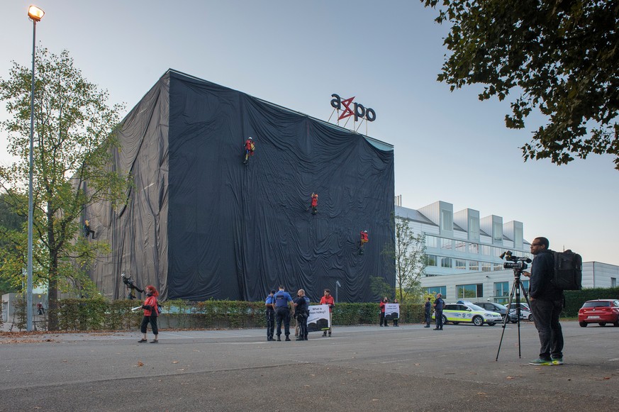 HANDOUT - Rund 30 Aktivistinnen und Aktivisten von Greenpeace haben heute Morgen ein Glasgebaeude des Axpo-Hauptsitzes in Baden (AG) mit schwarzem Stoff verhuellt. Mit der Protest-Aktion wollen sie di ...