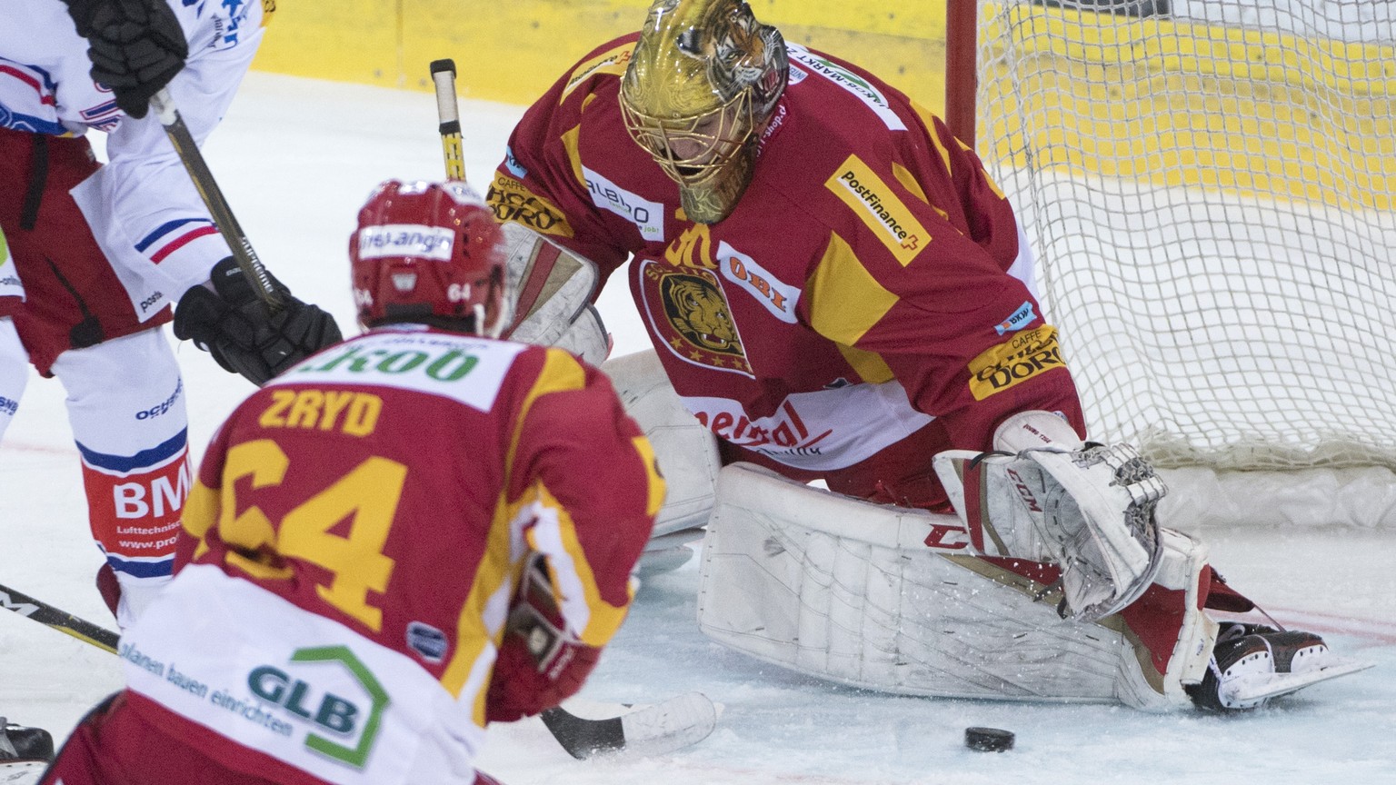 Tigers Goalie Akira Schmid, rechts, und Tigers Miro Zryd, kaempfen um den Puck, gegen Klotens Adrian Welti, links, im fuenften Eishockey Spiel der Platzierungsrunde der National League zwischen den SC ...