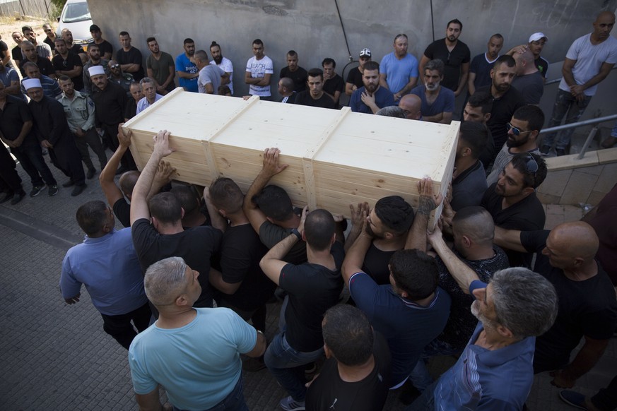 Druze men carry the coffin of Israeli police officer Advanced Staff Sgt. Maj. Hael Sathawi in Mughar, Israel, Friday, July 14, 2017. Arab assailants struck at ground zero of the Israeli-Palestinian co ...