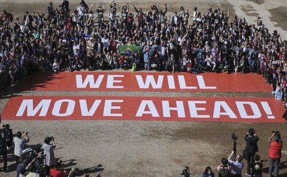 Participants at the COP22 climate conference stage a public show of support for climate negotiations and Paris agreement, on the last day of the conference, in Marrakech, Morocco, Friday, Nov. 18, 201 ...