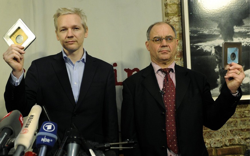 2011: Julian Assange nimmt die CDs von Rudolf Elmer vor den versammelten Medien in Empfang.