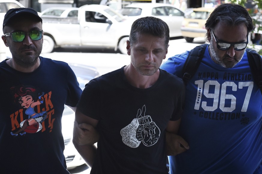 A Russian man is escorted by police officers as he arrives at a courthouse at the northern Greek city of Thessaloniki, Wednesday, July 26, 2017. Greek authorities say they have arrested a Russian man  ...