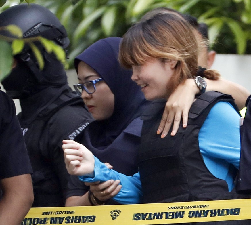 Vietnamese suspect Doan Thi Huong, right, arrested in the death of Kim Jong Nam, is escorted by police officers as she leaves a court house in Sepang, Malaysia, Thursday, April 13, 2017. Malaysian aut ...