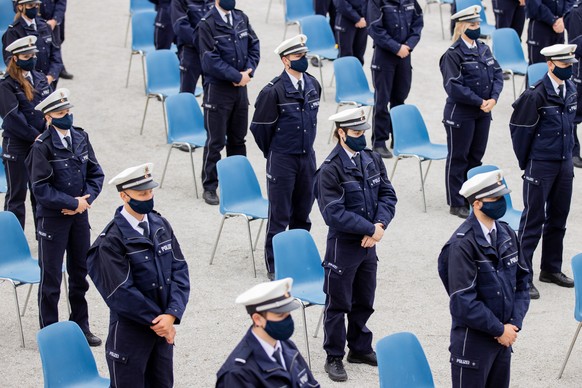 ARCHIV - 09.09.2020, Nordrhein-Westfalen, Br�hl: Kommissar-Anw�rter und -Anw�rterinnen stehen mit Mund-Nasenschutz bei der Vereidigungsfeier der Polizeien K�ln, Bonn und Aachen vor dem zum UNESCO-Welt ...