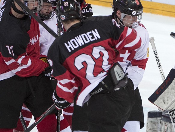 Switzerland&#039;s goalkeeper Joren van Pottelberghe, right, and Canada&#039;s Nicolas Roy, left, and Brett Howden, center, play for the puck during a the ice hockey U18 World Championships bronce med ...