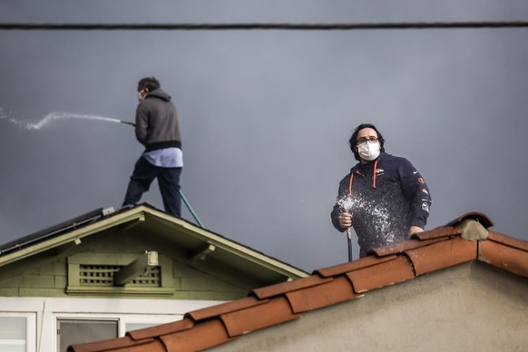 Nachrichten Linkding epa11813611 People use garden hoses to protect a roof from embers as the Eaton wildfire burns nearby in Altadena, California, USA, 08 January 2025. According to data from California Department of Fore ...