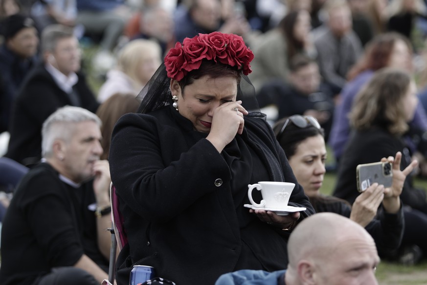 A woman reacts in Hyde Park while watching the State Funeral Service of Britain&#039;s Queen Elizabeth II on giant screens, Monday, Sept. 19, 2022 in London. (AP Photo/Lewis Joly)