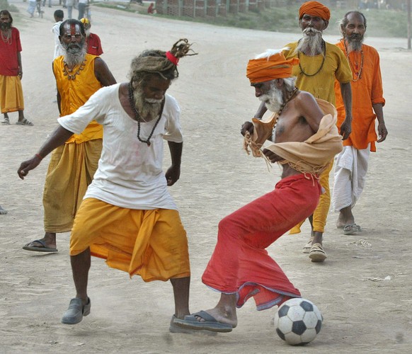 Hindu ascetics play soccer on the banks of the River Ganges in Allahabad, India, Wednesday, June 21, 2006. (AP Photo/Rajesh Kumar Singh)