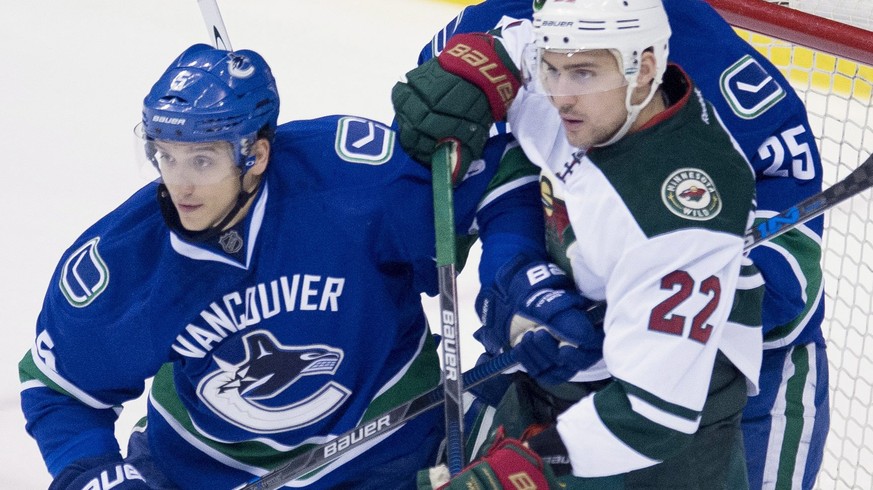 Vancouver Canucks defenceman Luca Sbisa (5) tries to clear Minnesota Wild right wing Nino Niederreiter (22) from in front of Vancouver Canucks goalie Jacob Markstrom (25) during first period NHL actio ...
