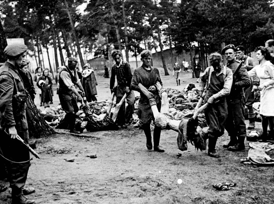 PA photo dated May 1945 of German SS men captured at Belsen concentration camp forced by Allied troops to carry the dead bodies of their victims. Some 10,000 guests from around the world are expected  ...