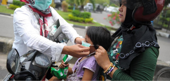 In Indonesien versuchen die Mütter ihre Kinder mit Mundmasken zu schützen.