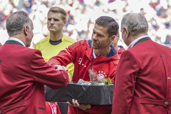 epa05976549 Bayern Munich&#039;s Xabi Alonso (C) receives a gift as he is bid farewell by Bayern Munich CEO Karl-Heinz Rummenigge (L) and President Uli Hoeness (R) prior his final German Bundesliga so ...