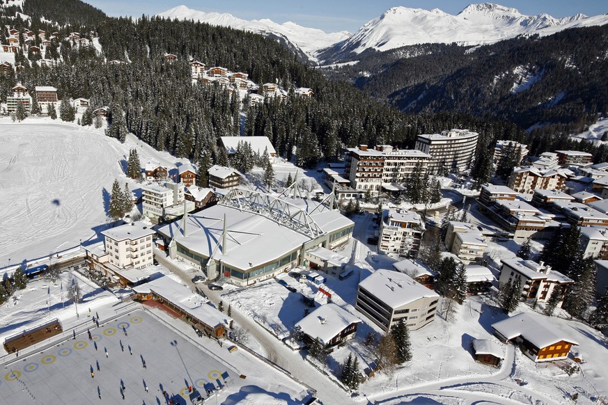 Curlingspieler, links, geniessen das herrliche Winterwetter am Sonntag, 16. Dezember 2007 in Arosa. In der Bildmitte die Eishalle Arosa.(KEYSTONE/Alessandro Della Bella)