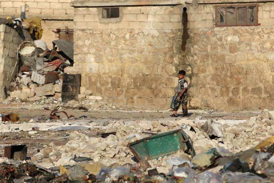 A boy walks past garbage and debris in the rebel-held al-Sheikh Said neighbourhood of Aleppo, Syria September 1, 2016. REUTERS/Abdalrhman Ismail