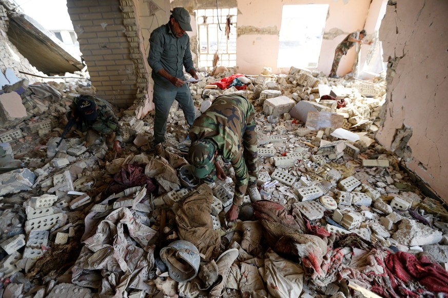 Schiitische Milizionäre untersuchen Leichenteile von irakischen Sicherheitskräften in Saklawija, nördlich von Falludscha.