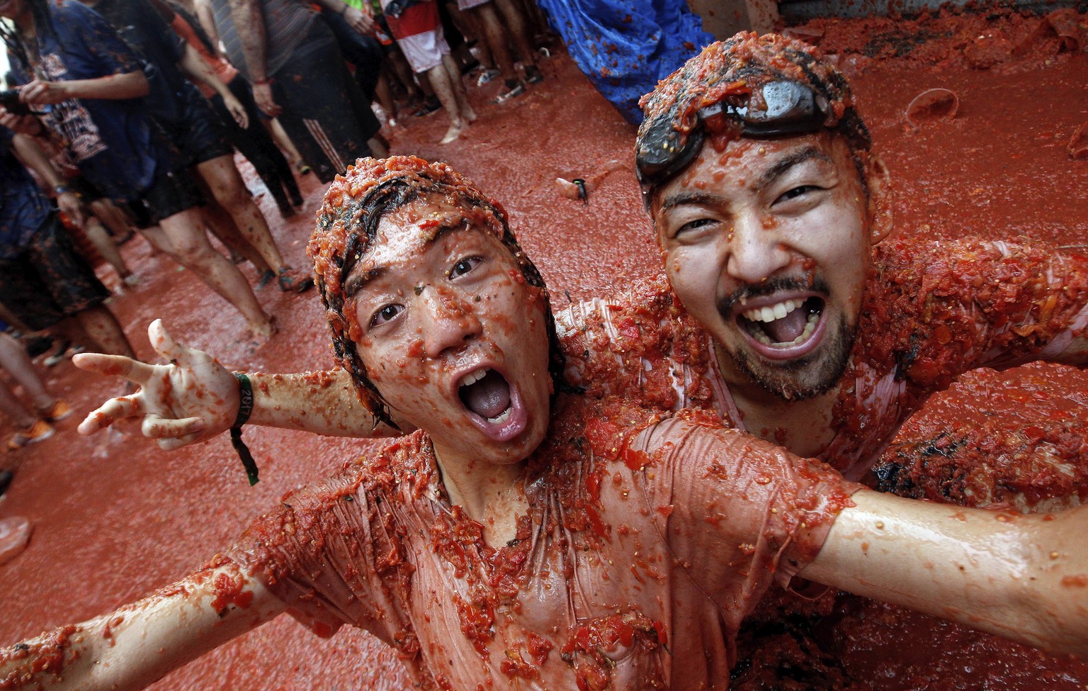 epa06171503 People covered in squashed tomatoes take part in the traditional tomato fight called &#039;Tomatina&#039; in Bunol, Spain, 30 August 2017. As every year on the last Wednesday of August, th ...