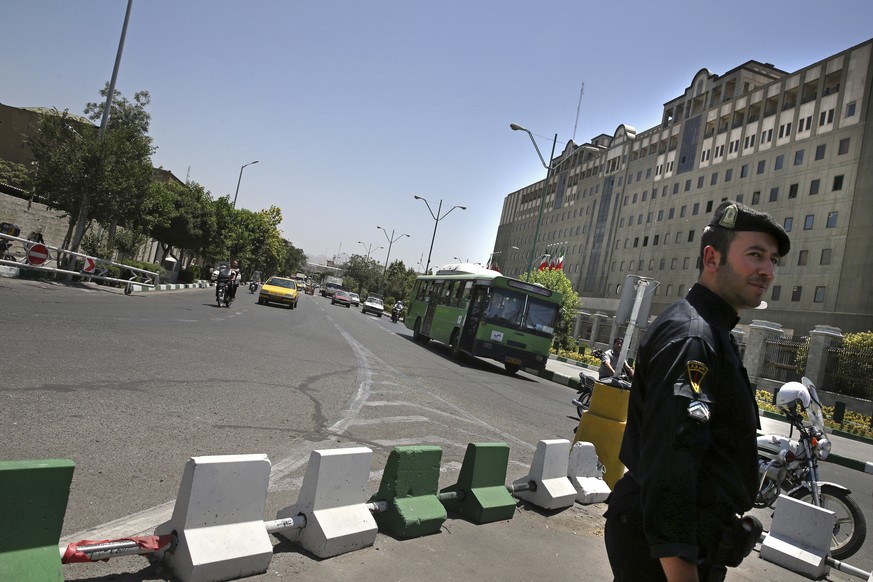 A police officer stands guard as vehicles drive in front of Iran&#039;s parliament building in Tehran, Iran, Thursday, May 8, 2017. Police increased their patrols in the streets and subway stations of ...