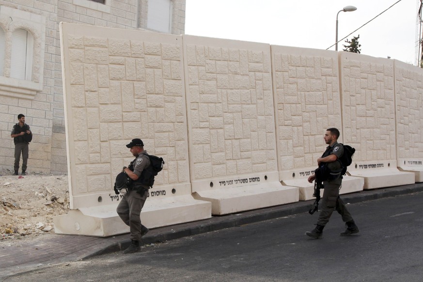 Grenzpolizisten hinter der Mauer.