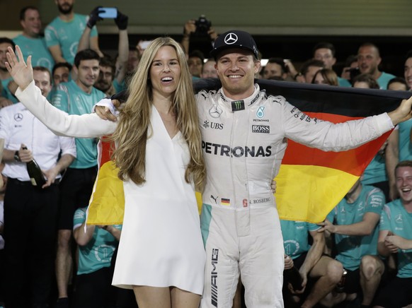 Mercedes driver Nico Rosberg of Germany celebrates with his wife Vivian Sibold holding a German flag in the team garage after winning the F1 2016 Championship in the Emirates Formula One Grand Prix at ...