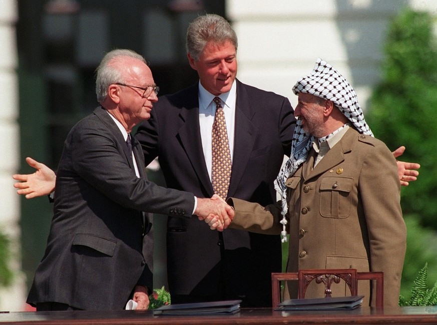 Der israelische Ministerpräsident Yitzhak Rabin und PLO-Chef Yassir Arafat reichen sich 1993 in Anwesenheit von US-Präsident Bill Clinton die Hand.&nbsp;