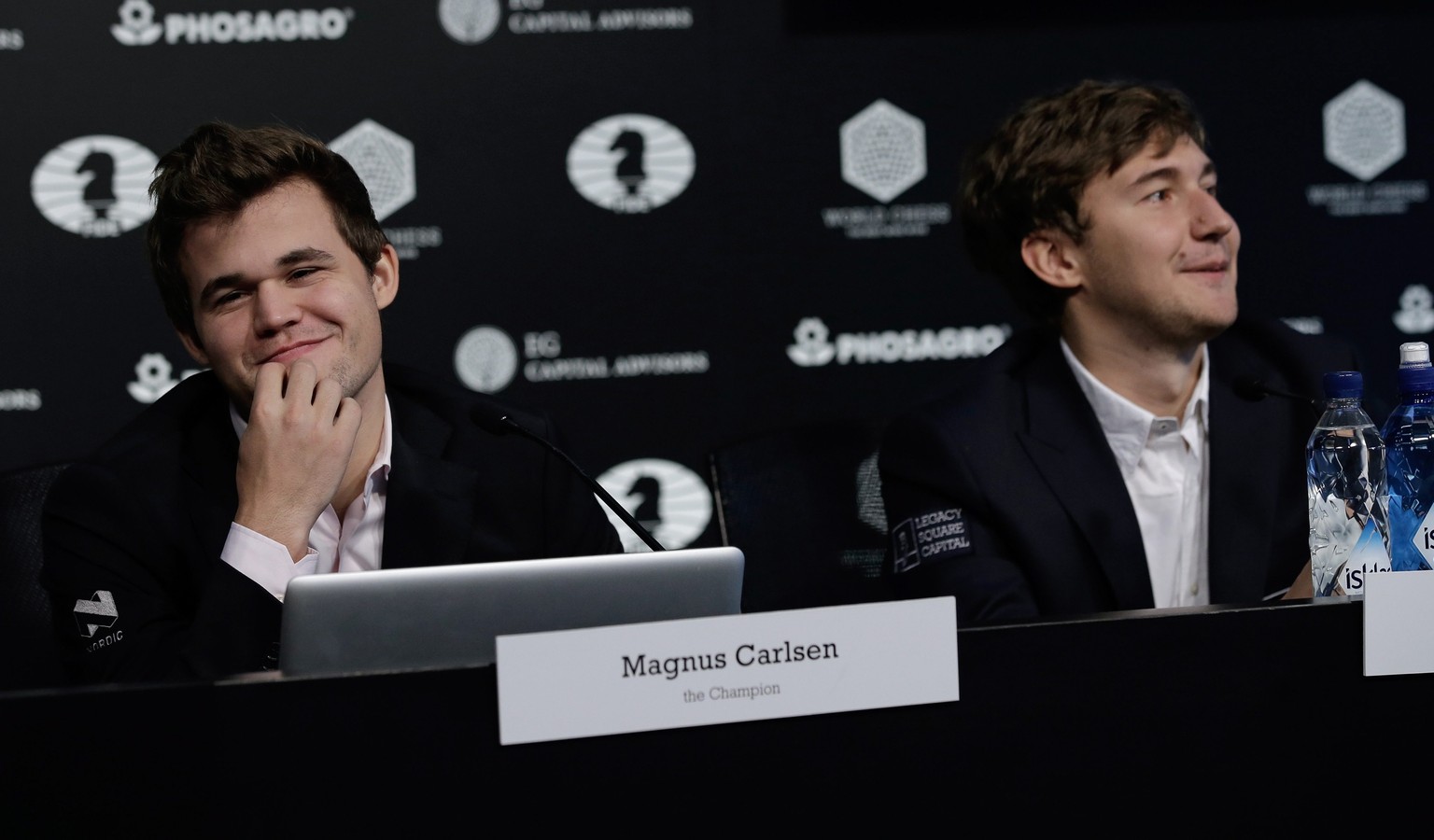 epa05651379 Chess players Magnus Carlsen (L) of Norway, the reigning world chess champion, and Sergey Karjakin, of Russia, attend a press conference after round 12 ended in a draw of the World Chess C ...