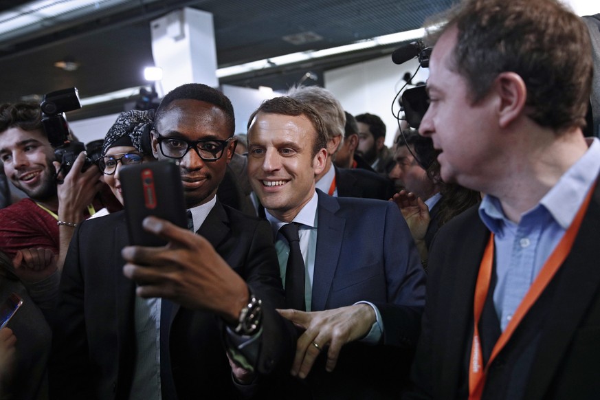 epa05766345 Former French Minister and candidate for the 2017 French Presidential Elections Emmanuel Macron (C) has a selfie photo during his visit to the Innovators fair (Salon des entrepreneurs) in  ...
