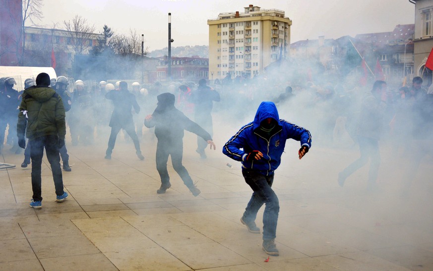 epa04588787 Kosovo police officers fire tear gas during clashes at a demonstration in Pristina, Kosovo, 27 January 2015. Police in Kosovo used water cannons and tear gas to disperse the second violent ...