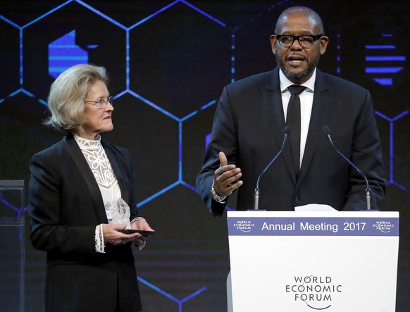 U.S. Actor and &#039;Crystal Award&#039; winner Forest Whitaker, right, speaks before receives a &#039;Crystal Award&#039; by Hilde Schwab, left, wife of WEF founder Klaus Schwab, during a ceremony on ...