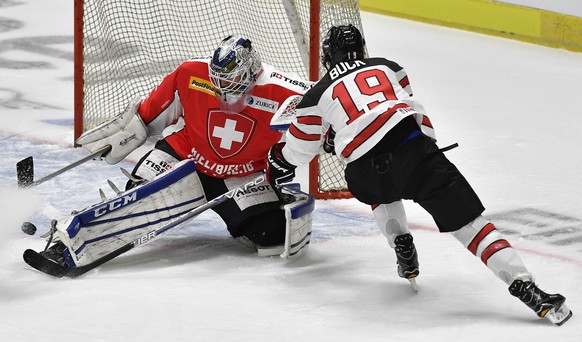 Switzerland&#039;s goalkeeper Tobias Stephan, left, fights for the puck against Canada&#039;s Brandon Buck during the Ice Hockey Deutschland Cup at the Curt-Frenzel-Eisstadion in Augsburg, Germany, Fr ...