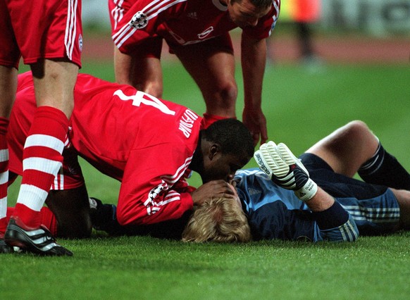 Torhüter Oliver Kahn erwacht nach einem Zusammenprall durch die Mund-zu-Mund-Beatmung von Sammy Kuffour (li.), Mannschaftsarzt Dr. Hans-Wilhelm Müller-Wohlfahrt (re., alle Bayern) kommt hinzu