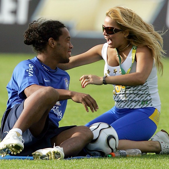 A Brazilian fan who broke the security kneels down to embrace Brazilian striker Ronaldinho after a training session at Thermoplan arena in Weggis, central Switzerland, Friday, May 26, 2006. Brazil wil ...