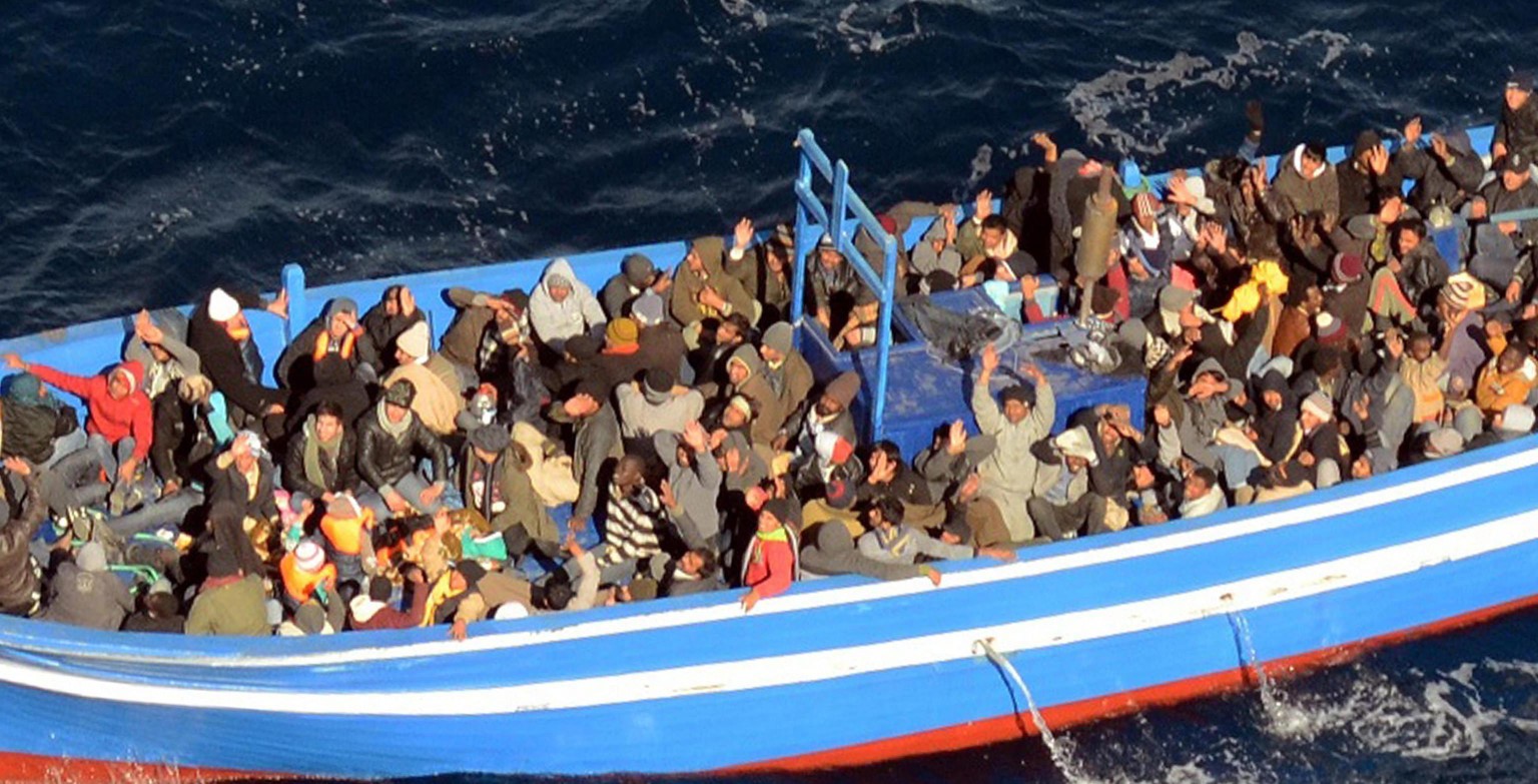 epa04036677 A handout photograph provided by the Italian Navy shows a boat with 200 migrants, off the coast of Lampedusa, Italy, 22 January 2014. The Italian navy said on 22 January it has sent a frig ...