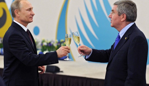 FILE - In this Feb. 24, 2014 file photo Russian President Vladimir Putin, left, toasts a glass of champagne with the International Olympic Committee President Thomas Bach during the official reception ...