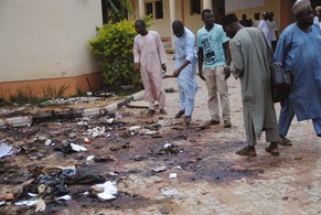 Passanten in der nigerianischen Stadt Zaria begutachten den Schaden nach einem Bombenanschlag am 7. Juli (Archivbild).