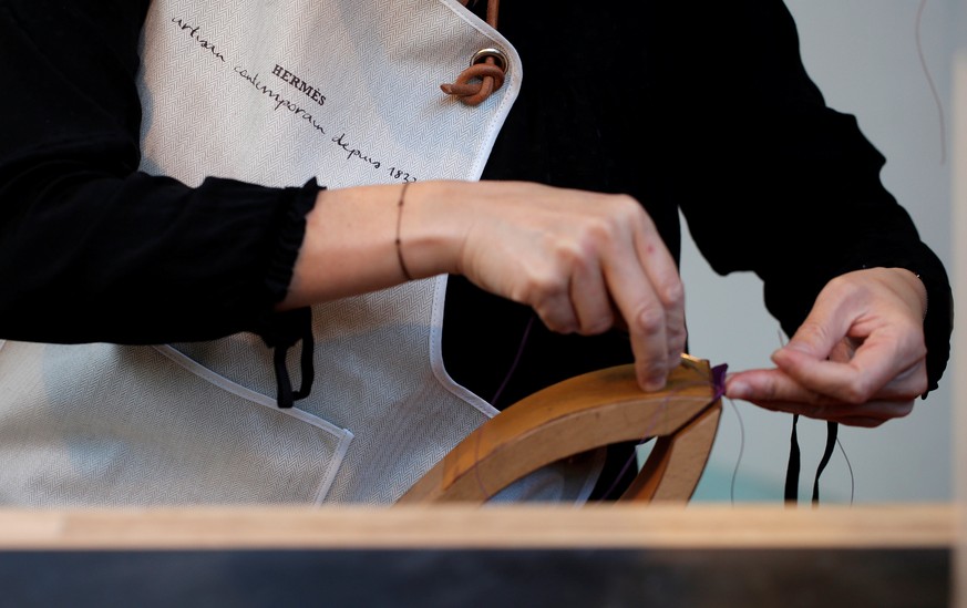 A leather craftswoman works on a Hermes luxury good displayed during the &quot;Hermes hors les murs&quot; (Hermes outdoors) event in Paris, France, November 18, 2016. REUTERS/Christian Hartmann