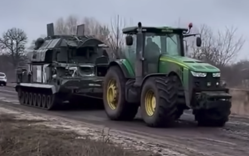 Ein ukrainischer Bauer schleppt einen russischen Panzer ab.