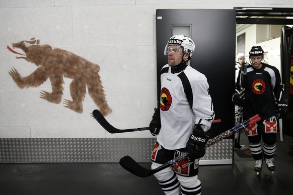 Die SC Bern Spieler Martin Pluess, vorne, und David Jobin kommen aus der Kabine zum ersten Training mit dem neuen Trainer Guy Boucher, am Dienstag, 28. Januar 2014 in der Postfinance Arena in Bern. (K ...