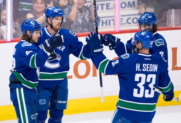 Vancouver Canucks&#039; Philip Larsen, of Denmark; and Daniel Sedin, Henrik Sedin and Loui Eriksson, all of Sweden, celebrate Daniel Sedin&#039;s goal against the Calgary Flames during the second peri ...