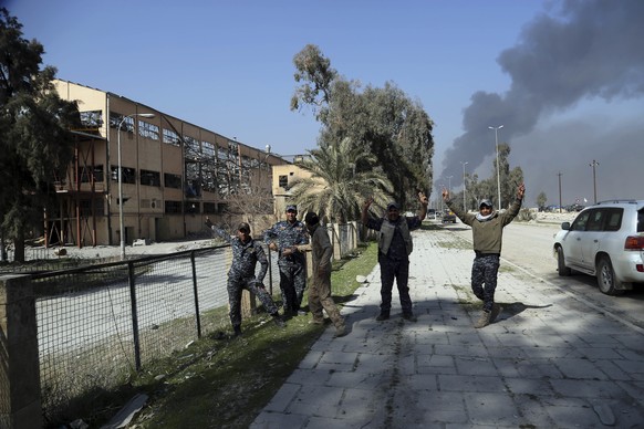 Iraqi Federal policemen celebrate while standing between the liberated airport and sugar plant in western Mosul, Iraq, Feb. 24. 2017. Iraqi forces pushed into the first neighborhood in western Mosul o ...