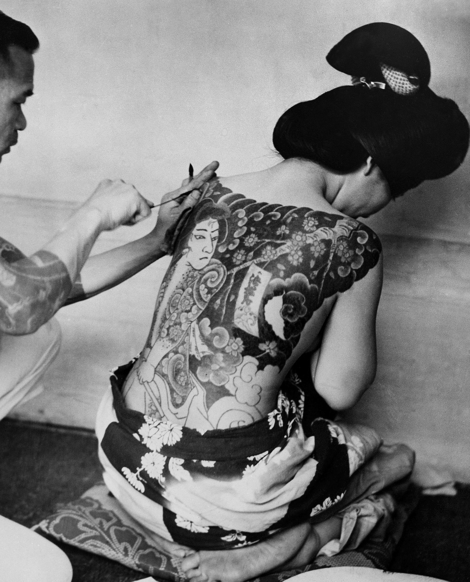 A tattoo artist traces delicate multi-colored figures on a Japanese woman, June 22, 1937. It often takes up to three years to complete a tattoo as large and detailed as this one, and costs between $15 ...