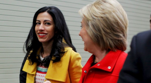 U.S. Democratic presidential candidate Hillary Clinton and her aide Huma Abedin walk away after an off-schedule stop at the &quot;I&#039;ll Make Me a World in Iowa Celebration Day&quot; in Des Moines, ...