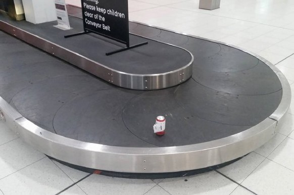 This handout photograph taken on July 8, 2017, and received on July 12 from Dean Stinson shows a can of beer on a baggage conveyor belt at the Perth Airport. A beer-loving Australian man has managed t ...