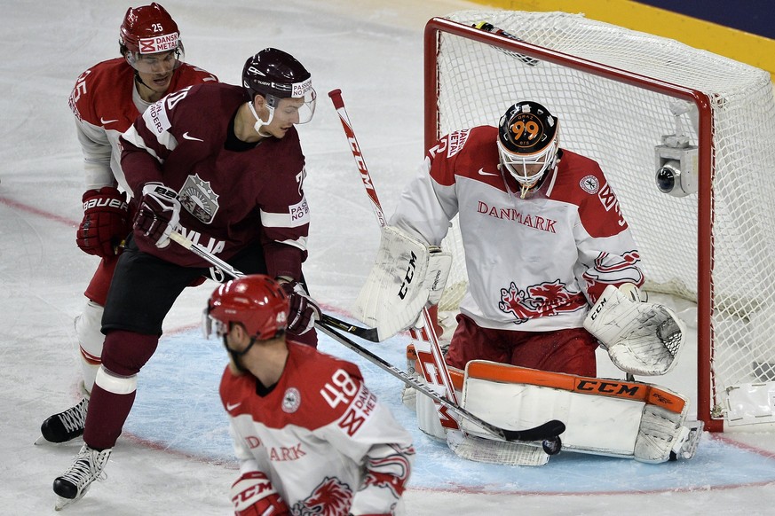 epa05946470 Denmark&#039;s goalie Sebastian Dahm (R) saves a shot of Latvia&#039;s forward Miks Indrasis (2-L) during the 2017 IIHF Ice Hockey World Championship group A preliminary round match betwee ...